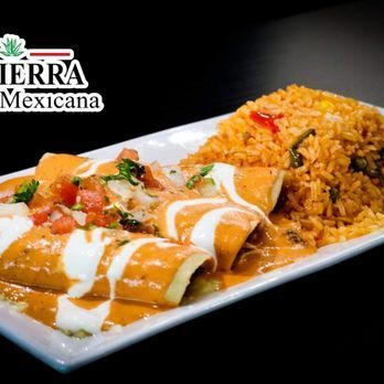 A white plate topped with enchiladas and rice.