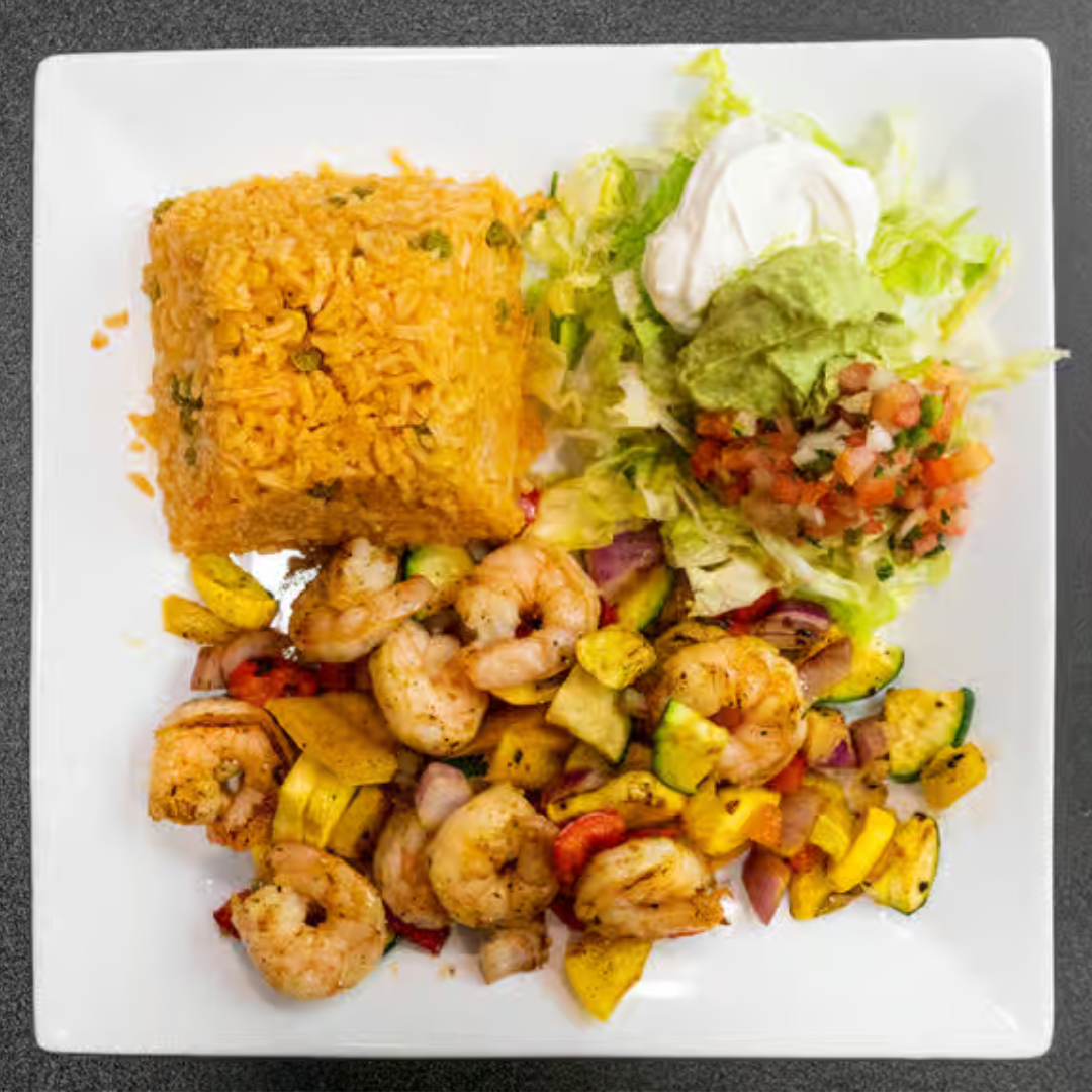 A white plate topped with shrimp , rice and vegetables.