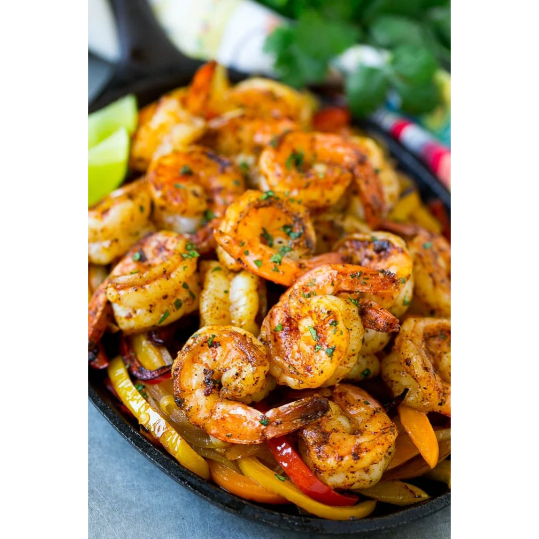 A skillet filled with shrimp and vegetables on a table.