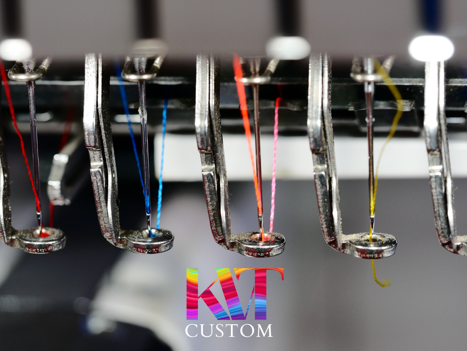 Close-up of an embroidery machine with multiple needles threaded in various colors.