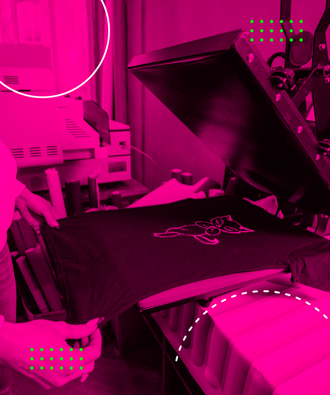 Person using a heat press to apply a design to a black t-shirt in a pink-toned workshop.