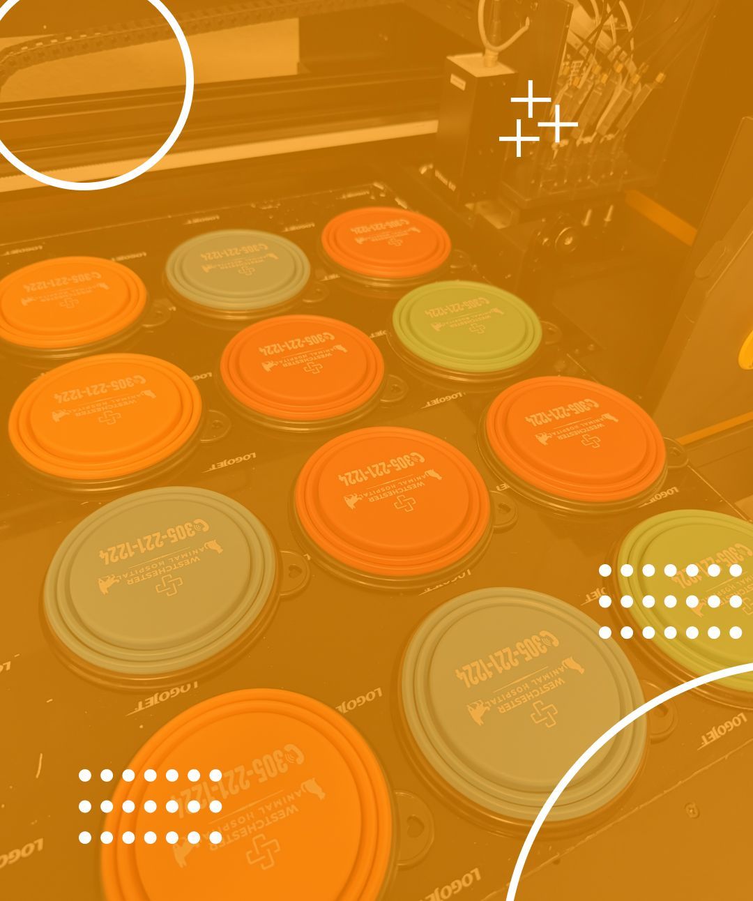 Orange and blue circular lids with text, arranged in a row. Inside a machine, in an industrial setting.
