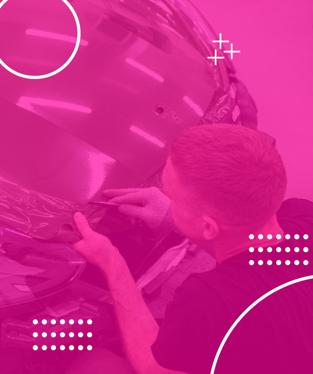 Man working on vehicle wrap, applying film with a blade; magenta color scheme.