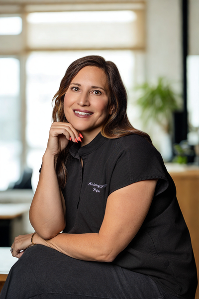 A woman in a black shirt is smiling for the camera