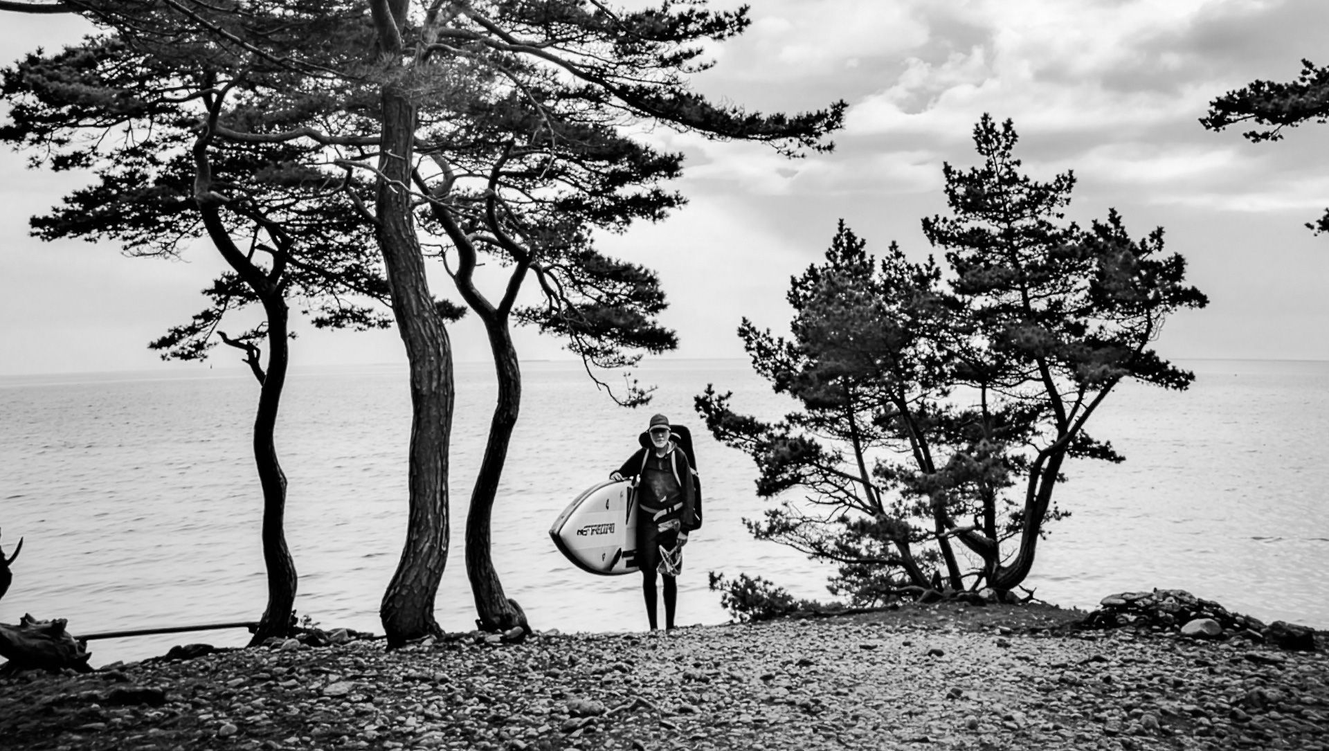 Erik walking on Torö stone beach, Sweden after a stand-up paddle