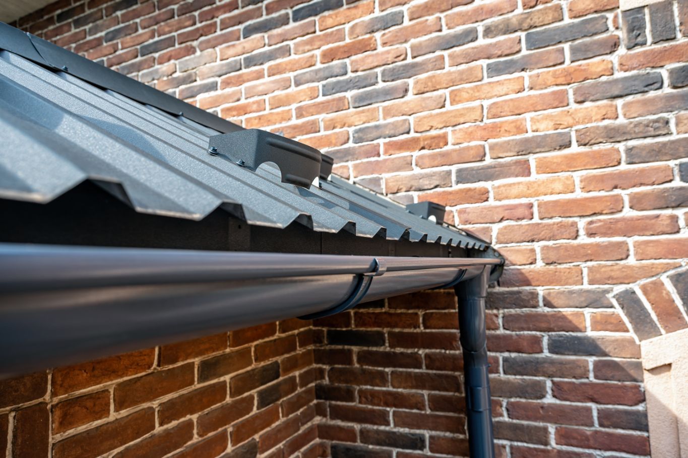 A Close Up of a Gutter on a Brick Wall— Stormguard Roofing In Caboolture, QLD