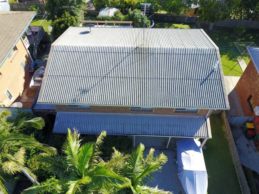 An Aerial View of a House With a Corrugated Metal Roof — Stormguard Roofing In Caloundra West, QLD