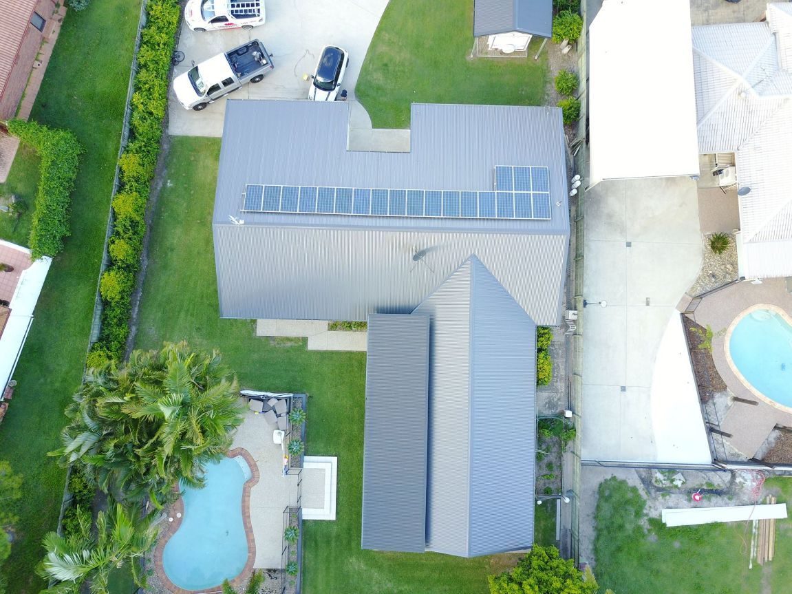 An Aerial View of a House With Solar Panels on the Roof — Stormguard Roofing In Caloundra West, QLD