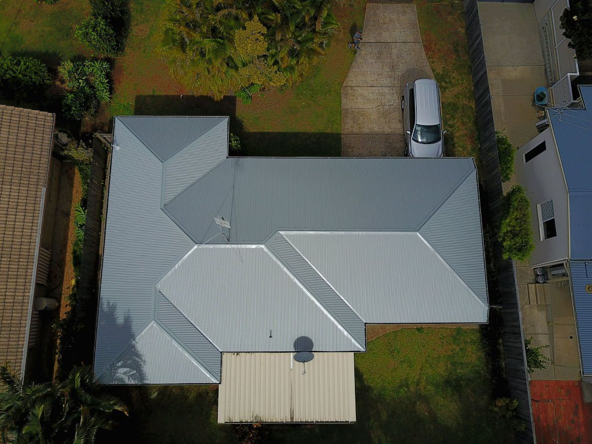 An Aerial View of a House With a Car Parked on the Roof — Stormguard Roofing In Caloundra West, QLD