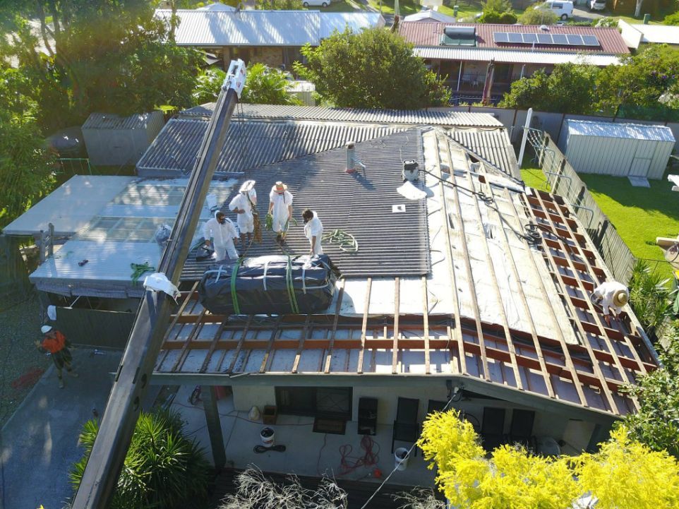 A Group of People Are Working on the Roof of a House — Stormguard Roofing In Caloundra West, QLD