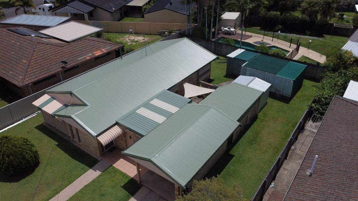 An Aerial View of a House With a Green Roof in a Residential Area — Stormguard Roofing In Sunshine Coast, QLD