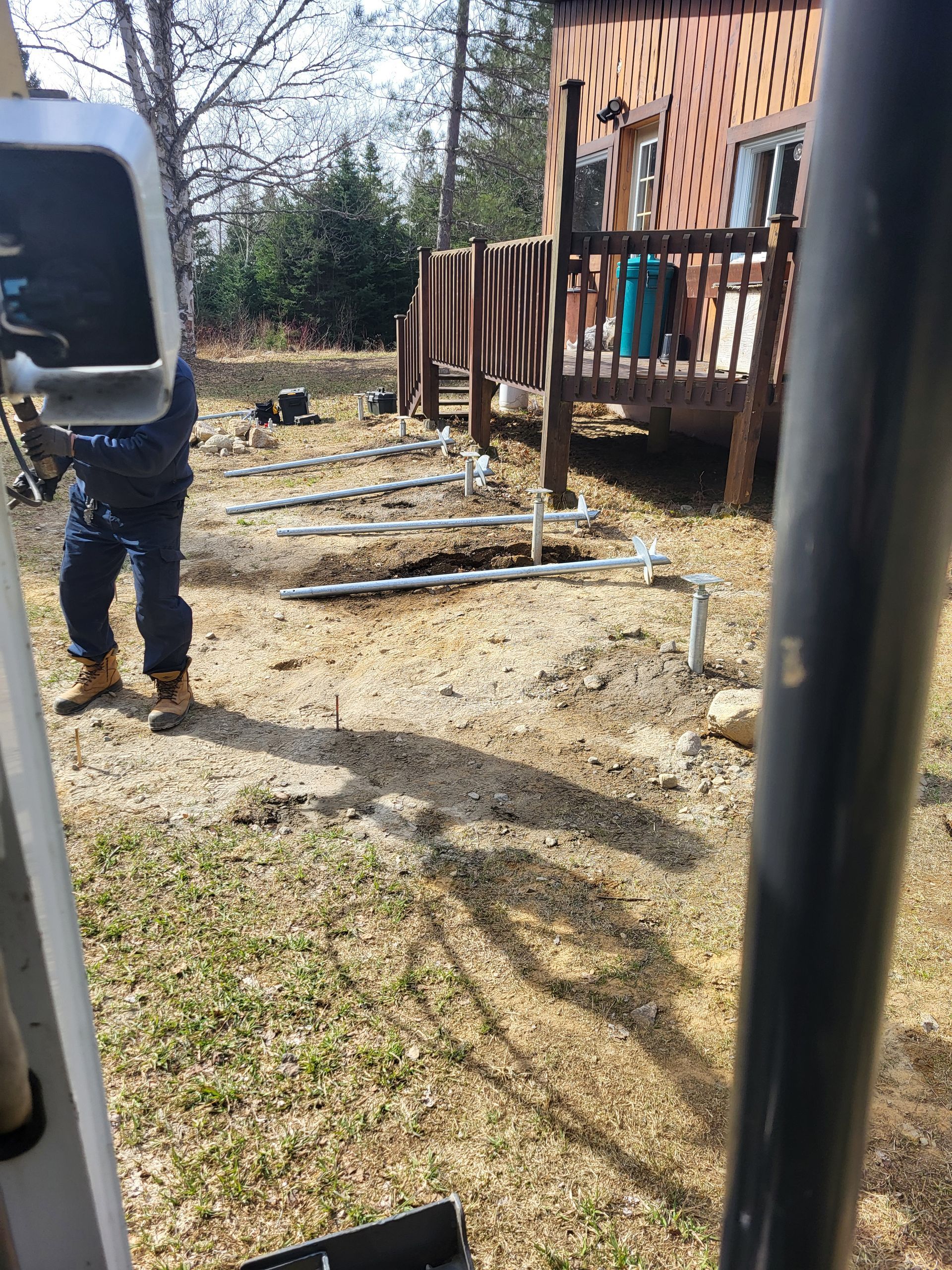 Un homme se tient debout dans la terre devant une maison.