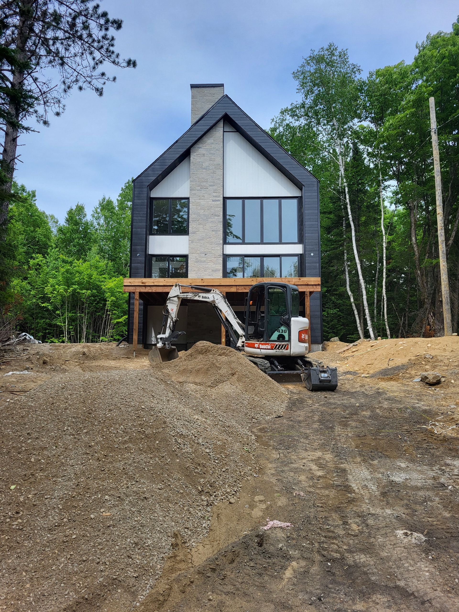 Une grande maison est en construction au milieu d'une forêt.
