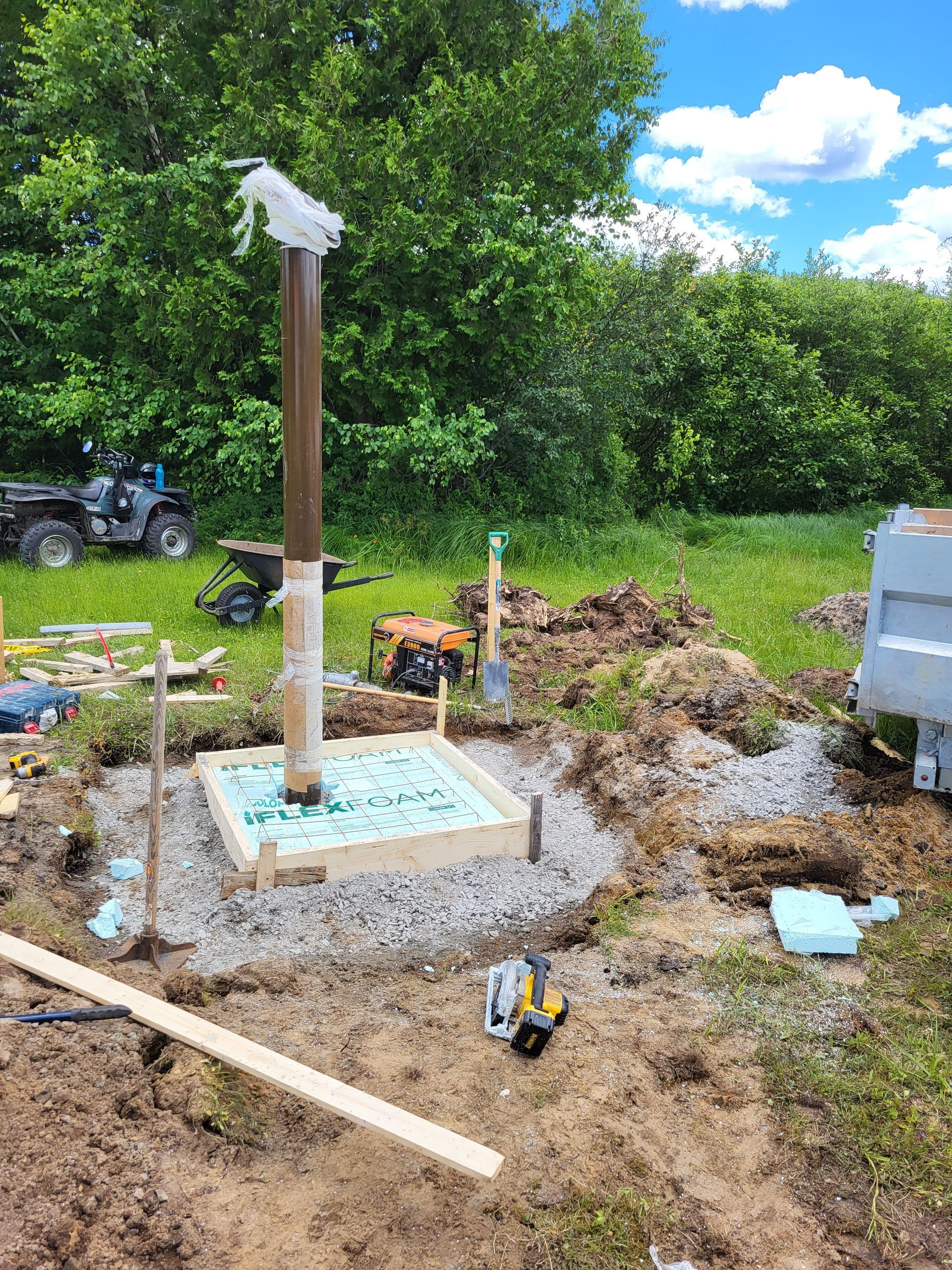Un poteau en bois est posé au milieu d'un champ de terre.