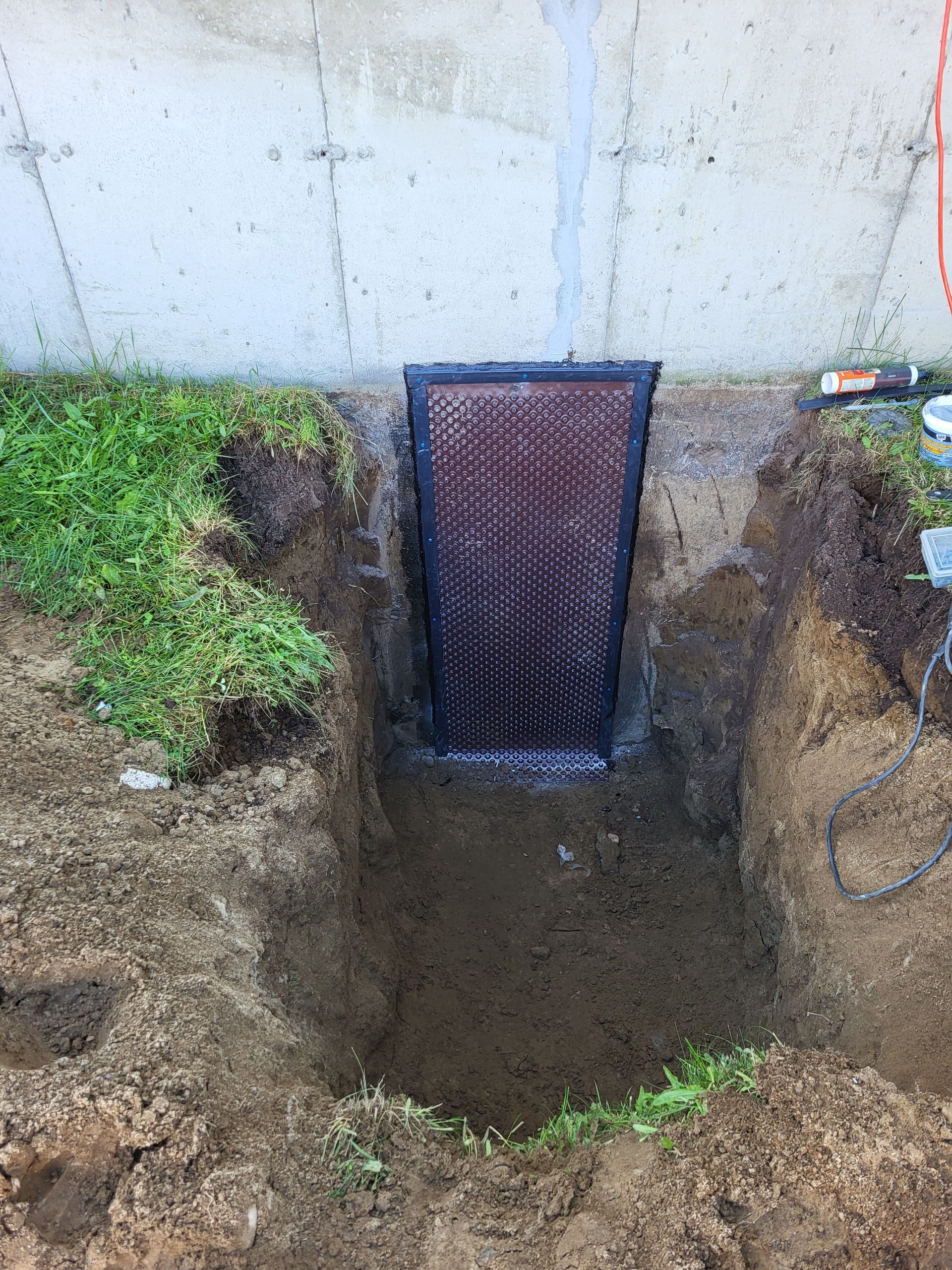 Un trou dans le sol à côté d'un mur avec une porte dedans.