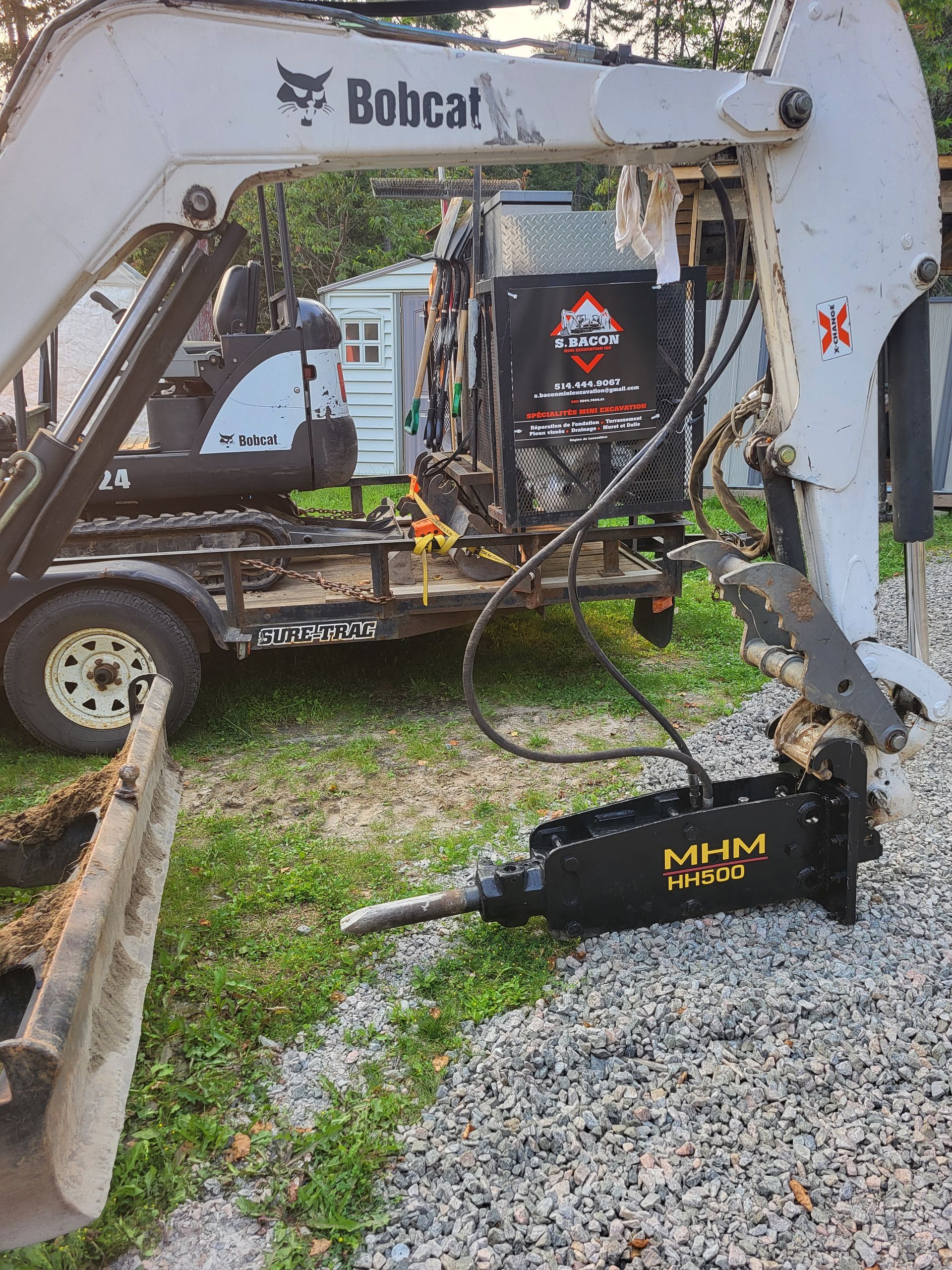 Une excavatrice Bobcat est assise sur une remorque.