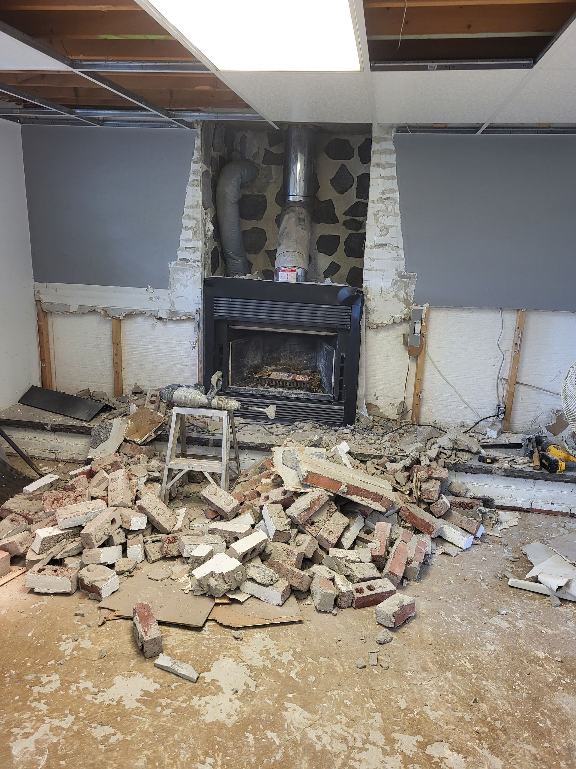 Une pièce avec une cheminée et beaucoup de briques au sol.