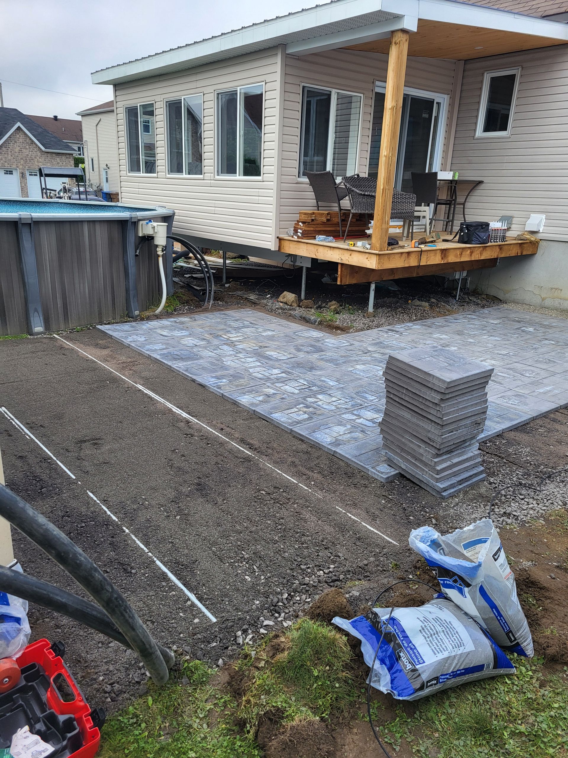 Une maison avec un patio en construction devant elle.