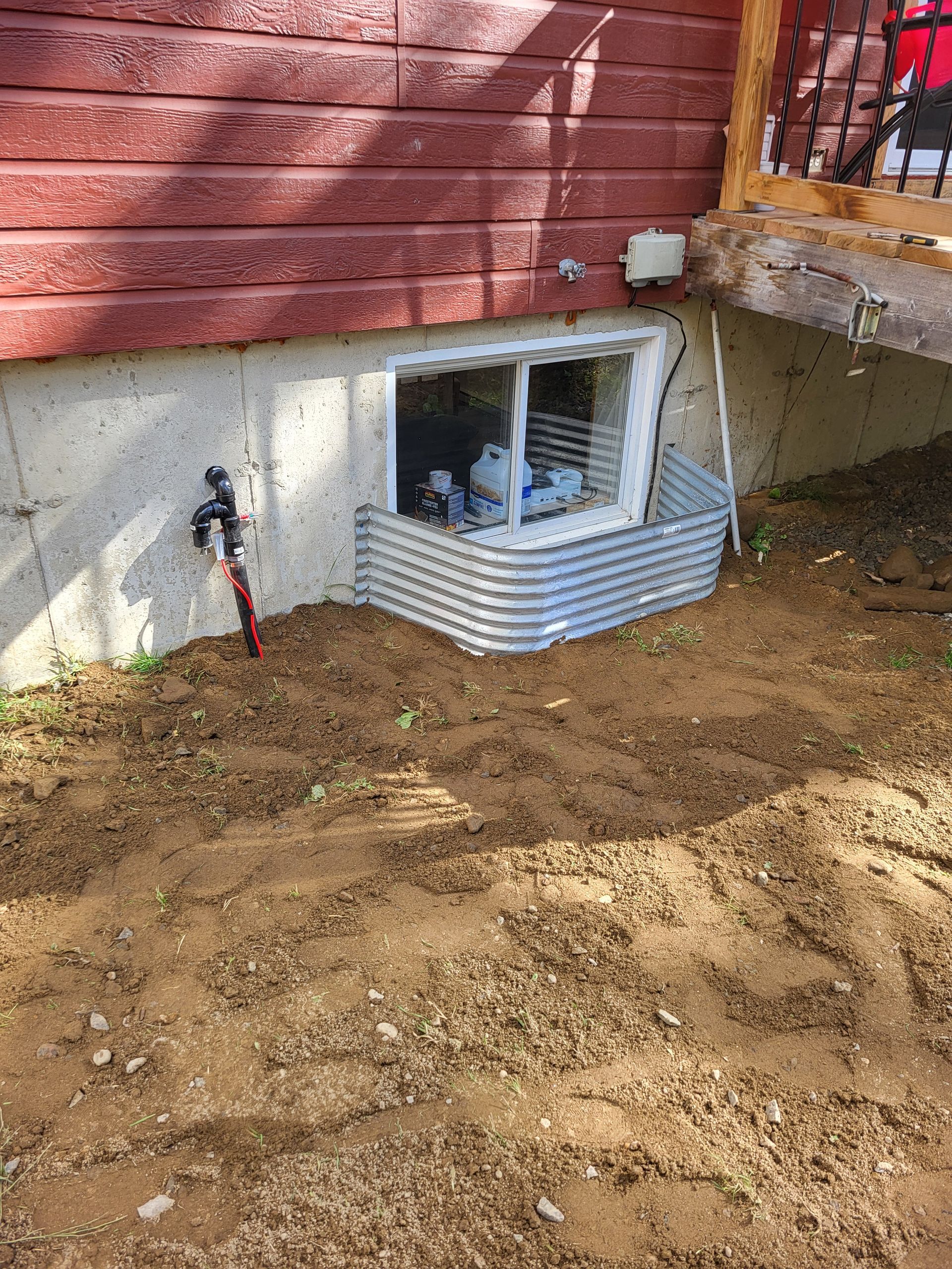 Il y a une fenêtre au sous-sol d'une maison.