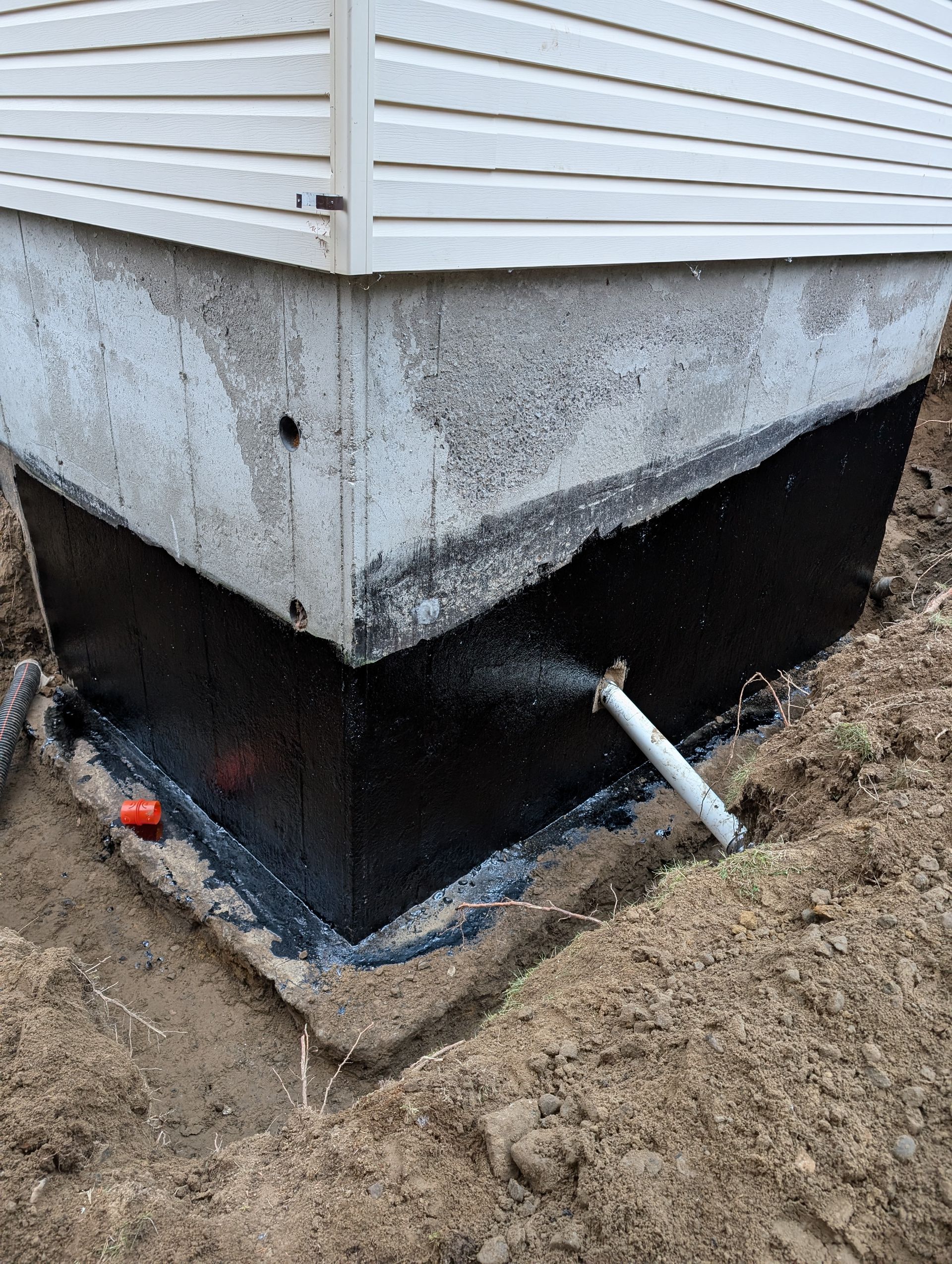 Un coin d'une maison avec un tuyau qui en sort.