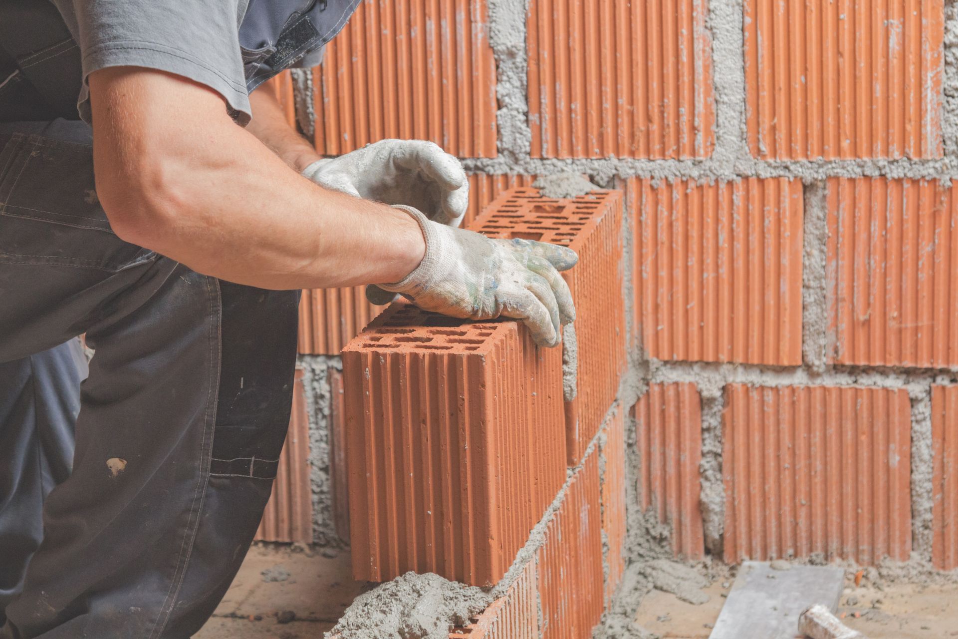 A man is laying bricks on a wall.