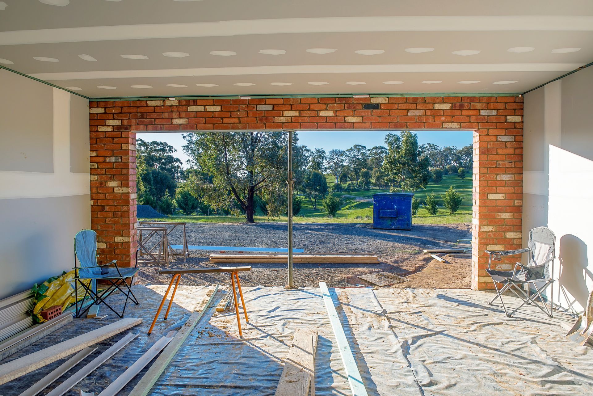A building under construction with a brick wall and a large window.
