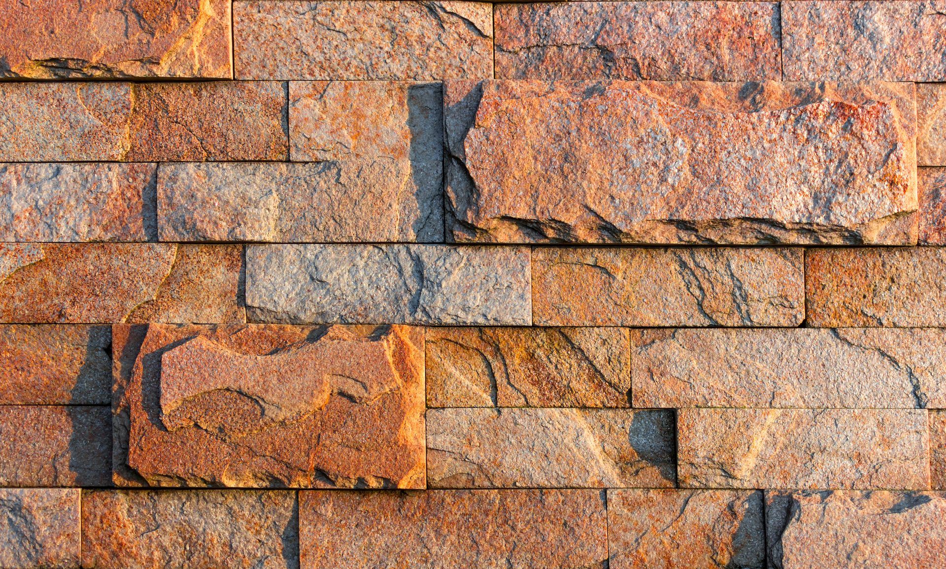 A close up of a brick wall with a shadow on it.