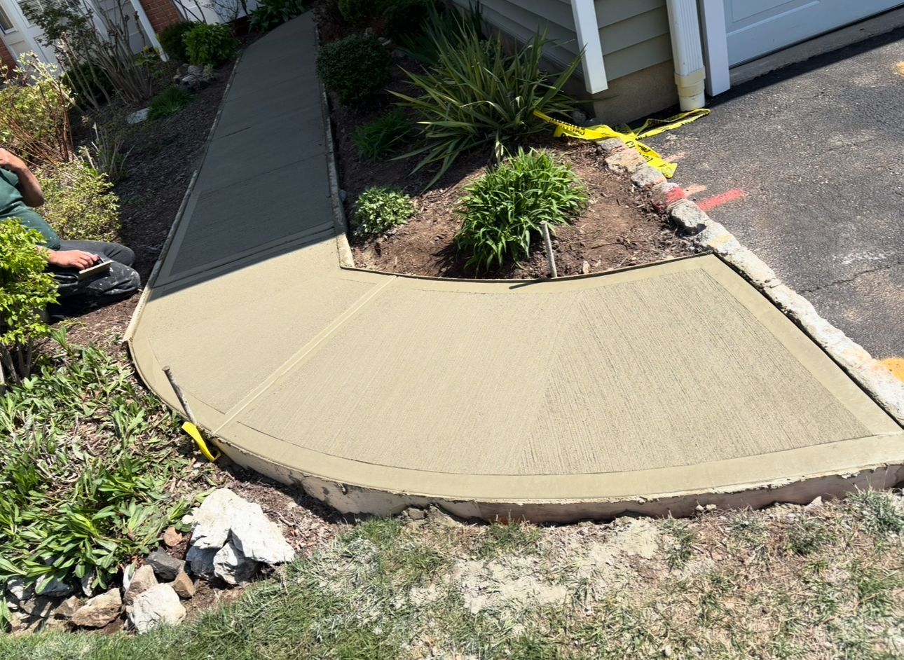 A concrete walkway is being built in front of a house.