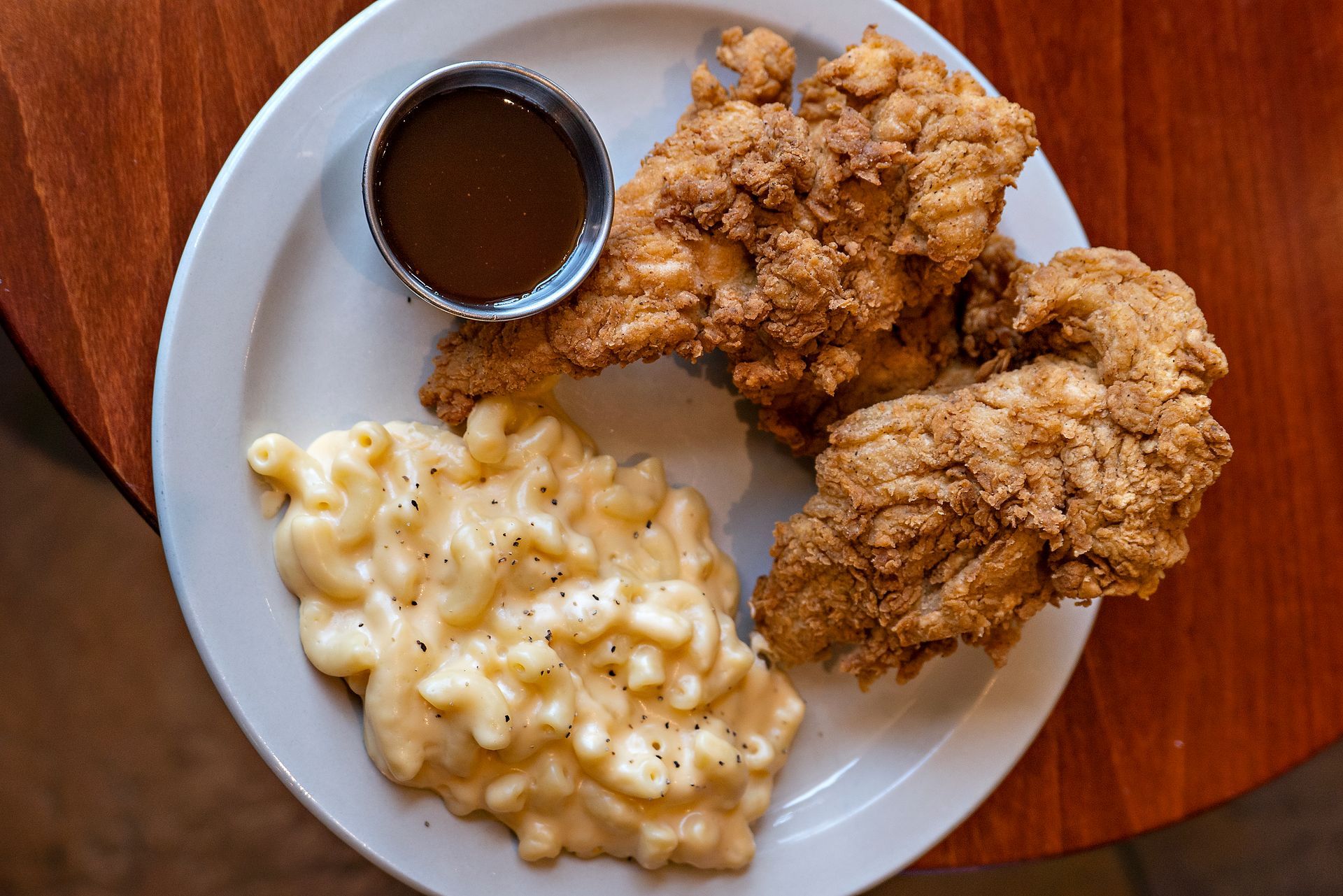 Fried chicken plate with mac and cheese and gravy.
