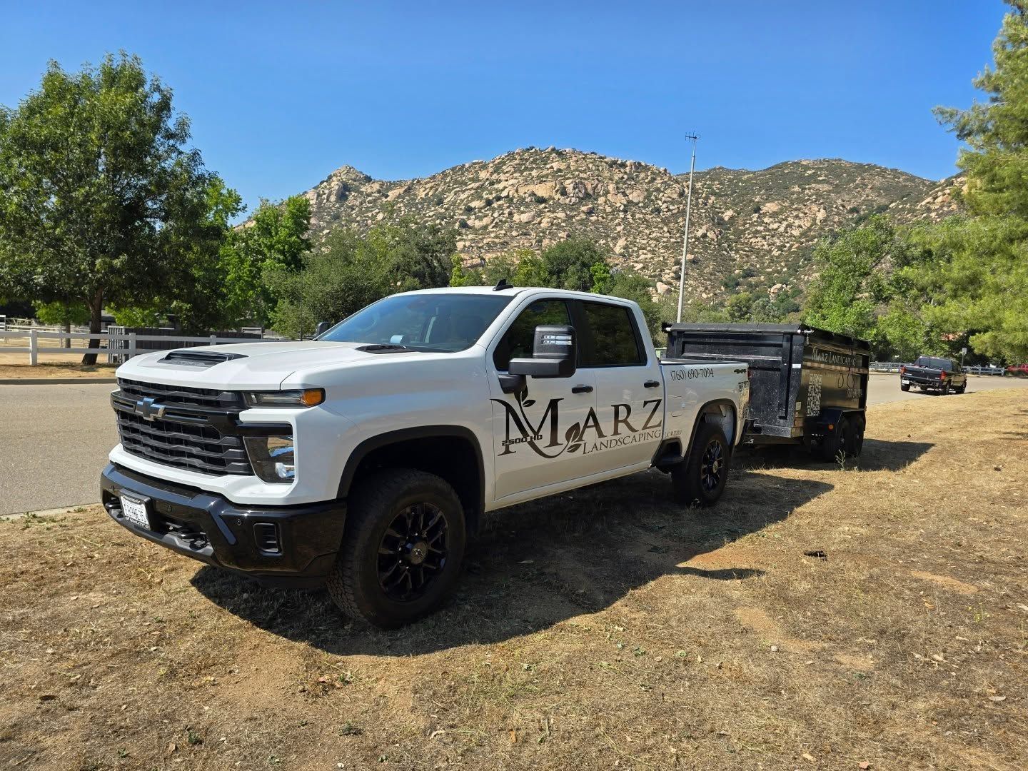 White Chevy truck with a trailer, branded with 