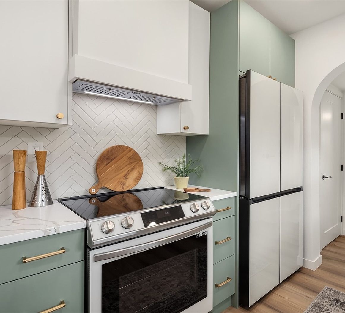 A kitchen with a stove top oven and a refrigerator