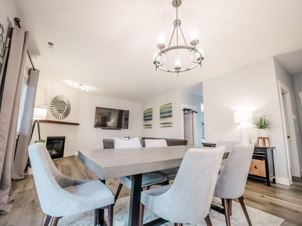 A dining room with a table and chairs and a chandelier.
