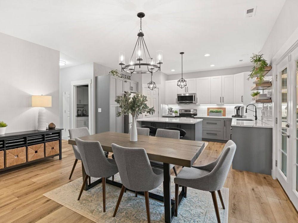 A dining room table and chairs in a kitchen with a chandelier.