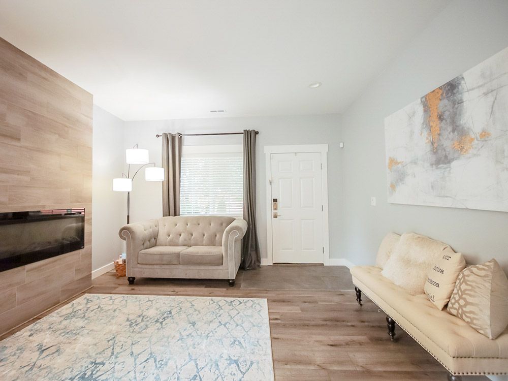 A living room with a couch , fireplace and rug.