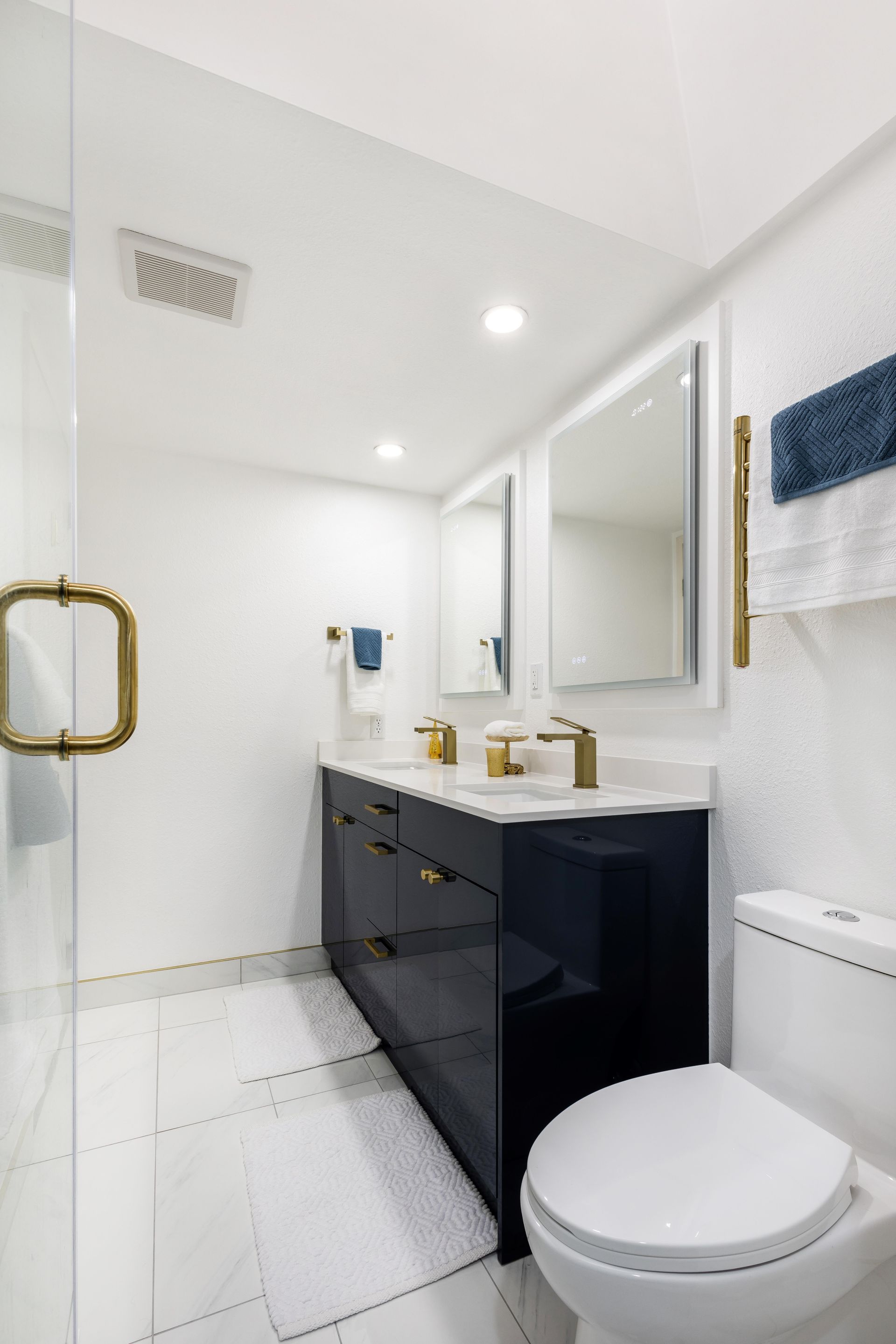 A bathroom with a toilet , sink , mirror and shower.