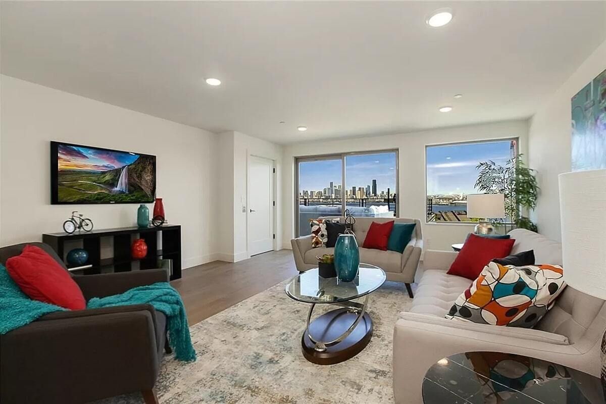 A living room with a couch , chair , coffee table and television.