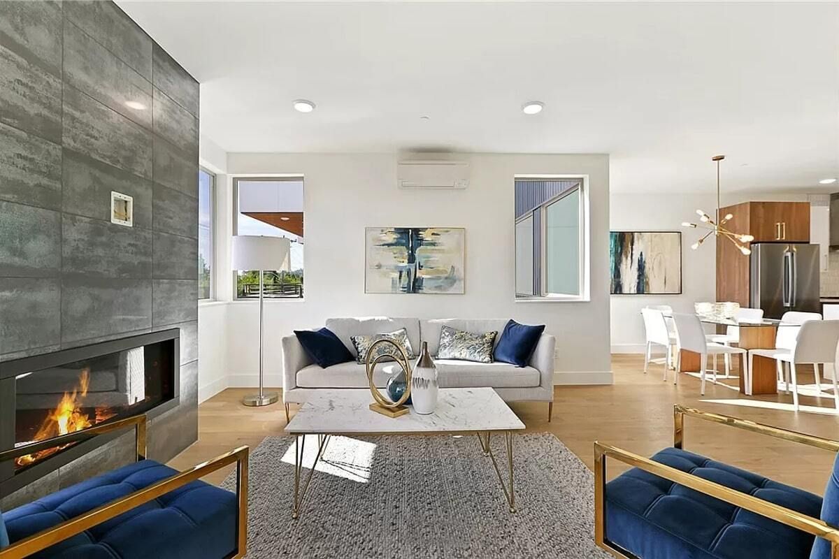 A living room with a couch , chairs , coffee table and fireplace.
