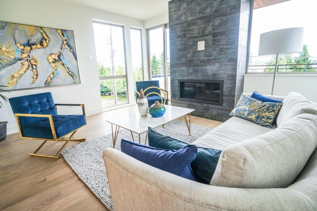A living room with a couch , chairs , coffee table and fireplace.