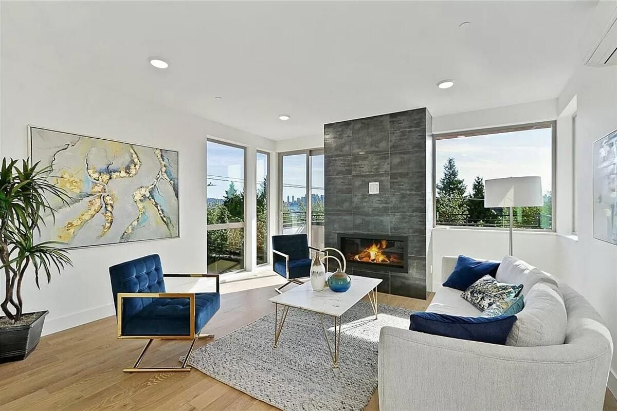 A living room with a couch , chairs , coffee table and fireplace.