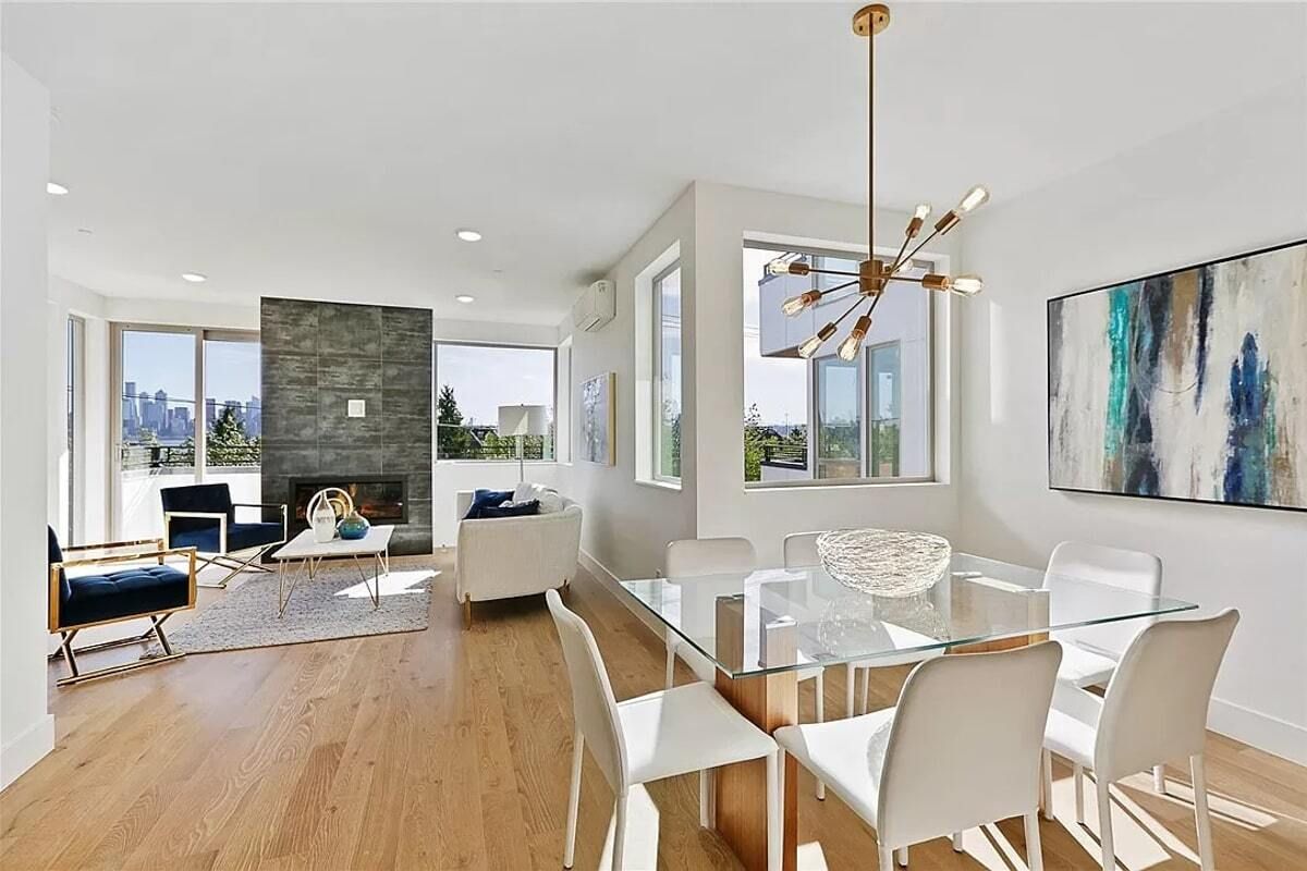 A living room with a dining table and chairs and a fireplace.