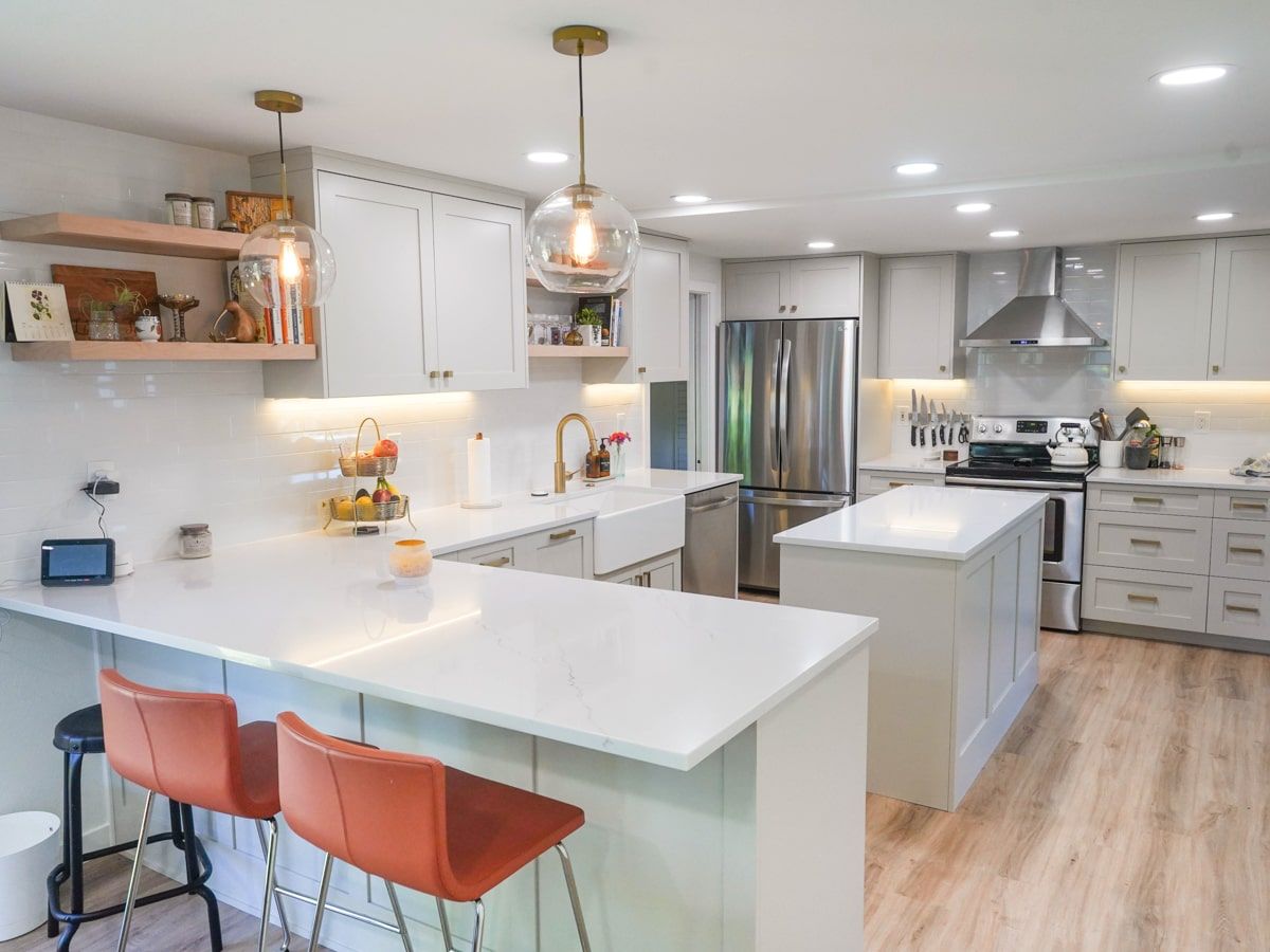 A kitchen with white cabinets , granite counter tops , stainless steel appliances , and a large island.