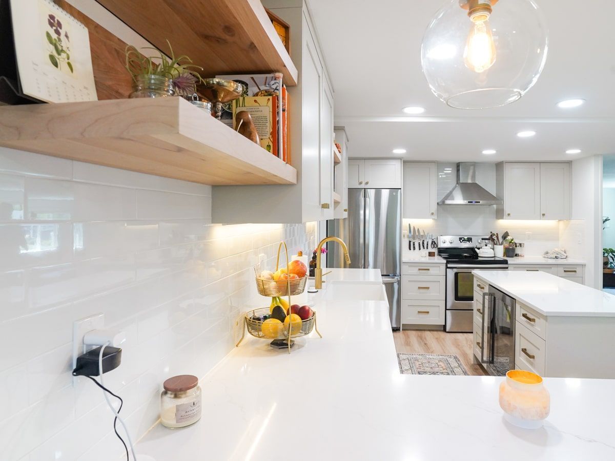 There is a bowl of fruit on the counter in the kitchen.
