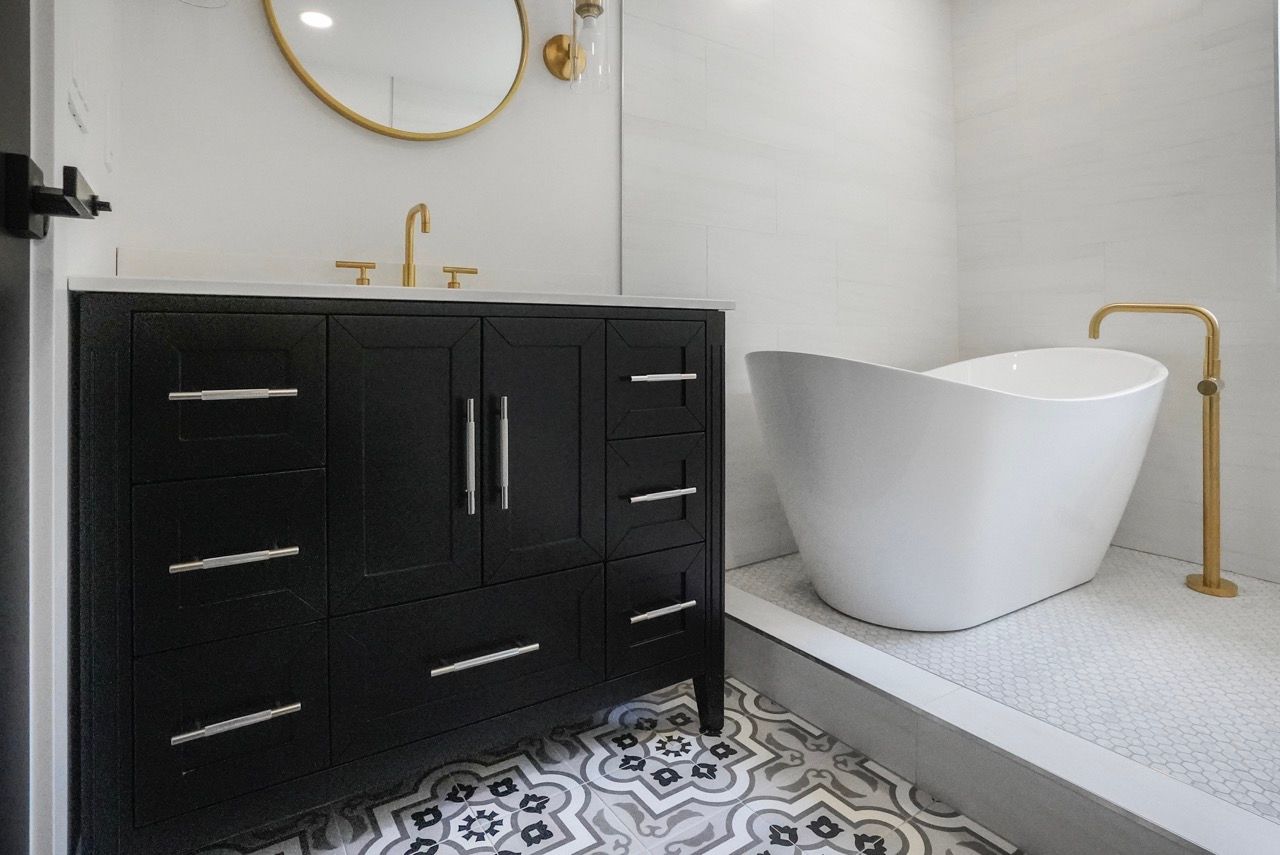 A bathroom with a bathtub , sink and mirror.