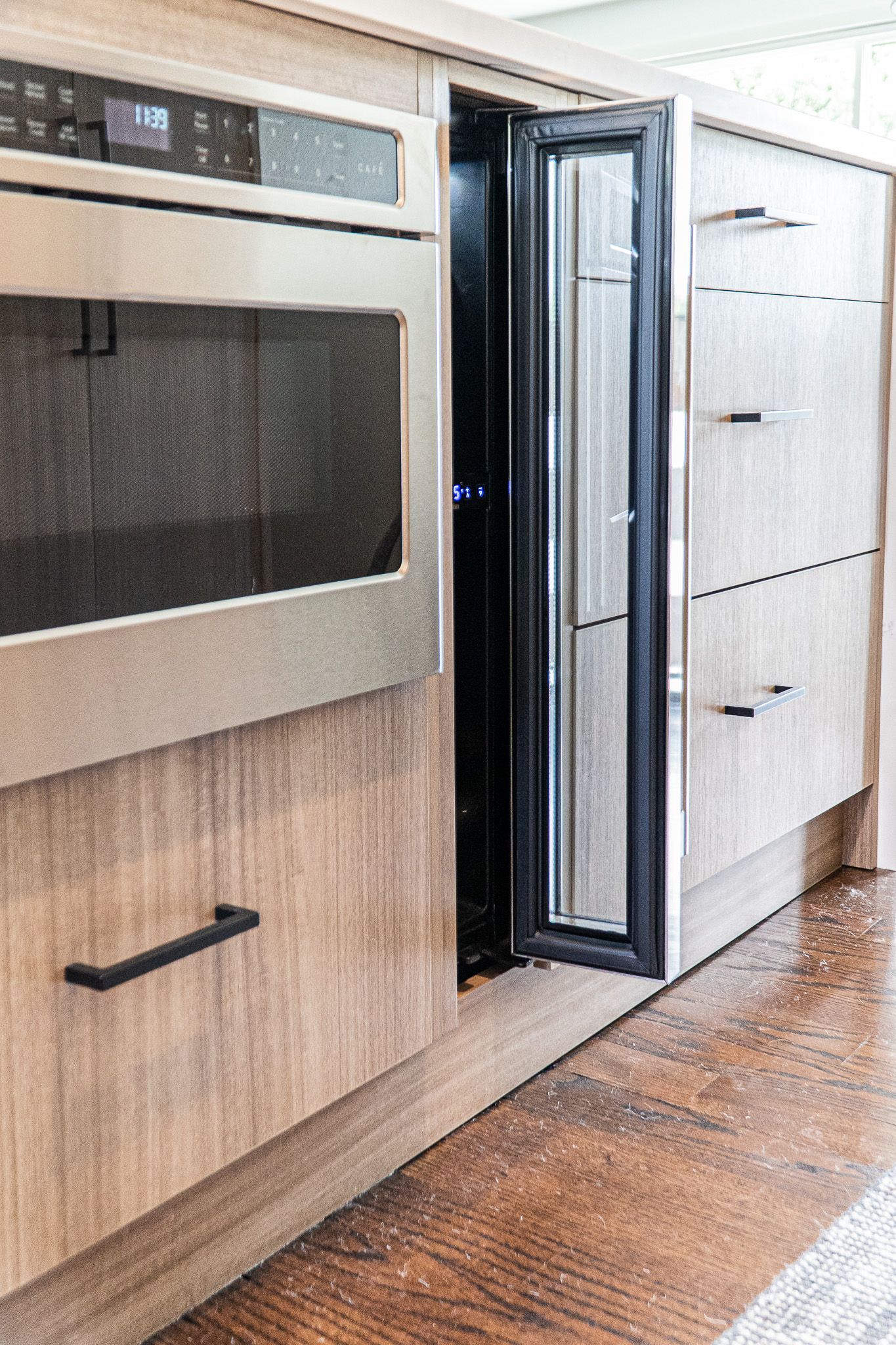 A kitchen with a stainless steel oven and a wine cooler.
