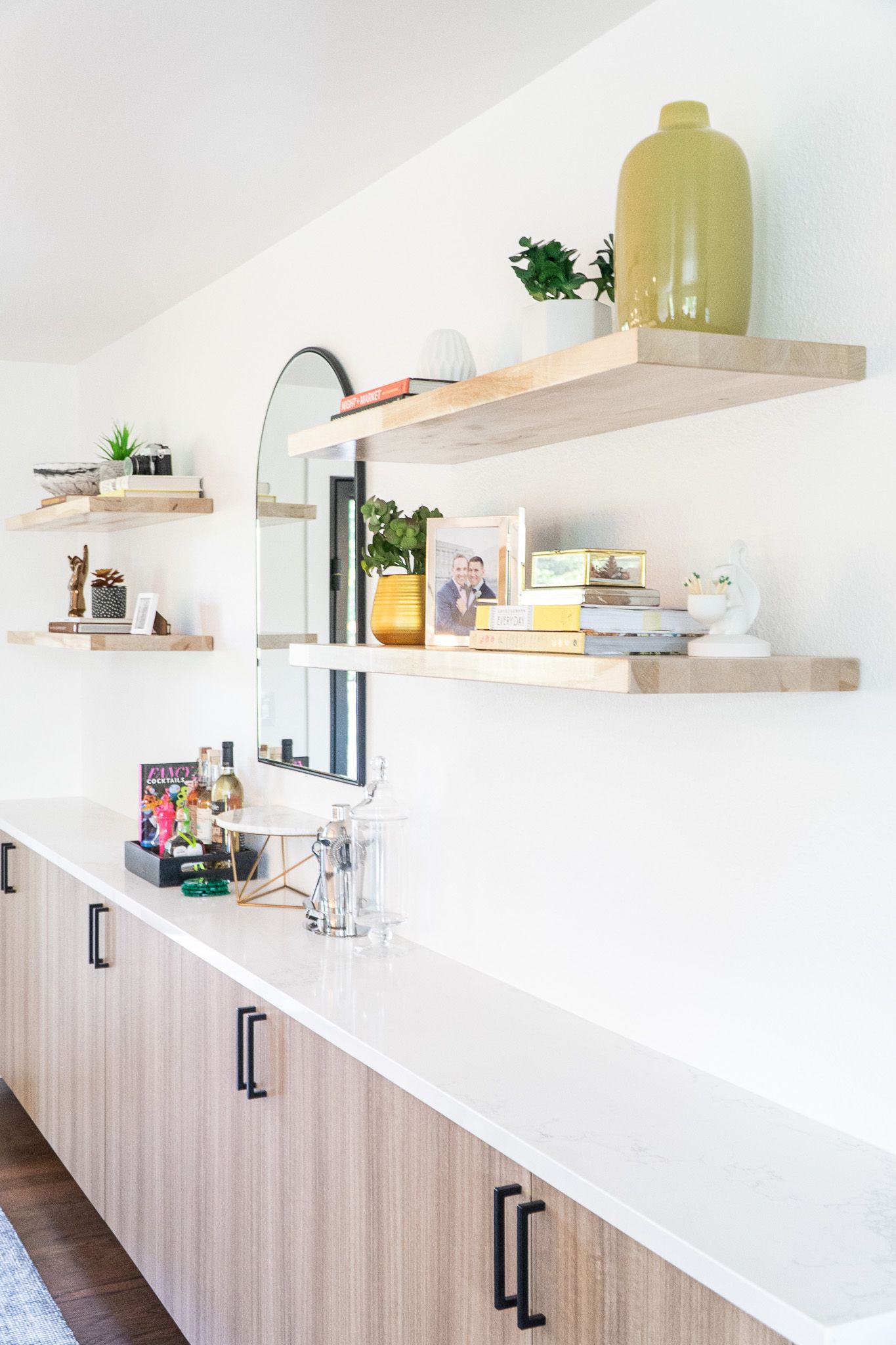 A kitchen with shelves , cabinets , and a mirror on the wall.