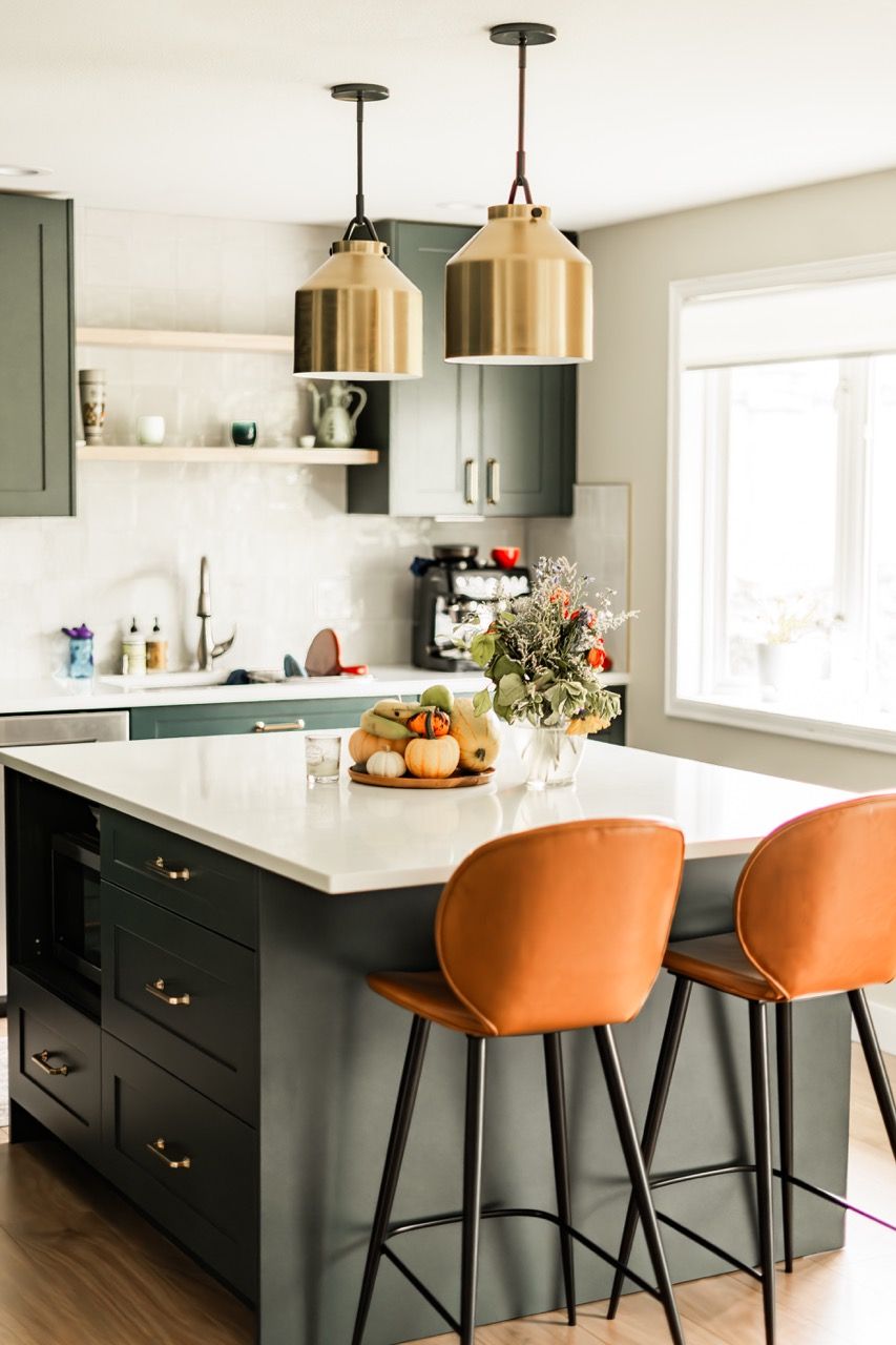 A kitchen with a large island and two bar stools.