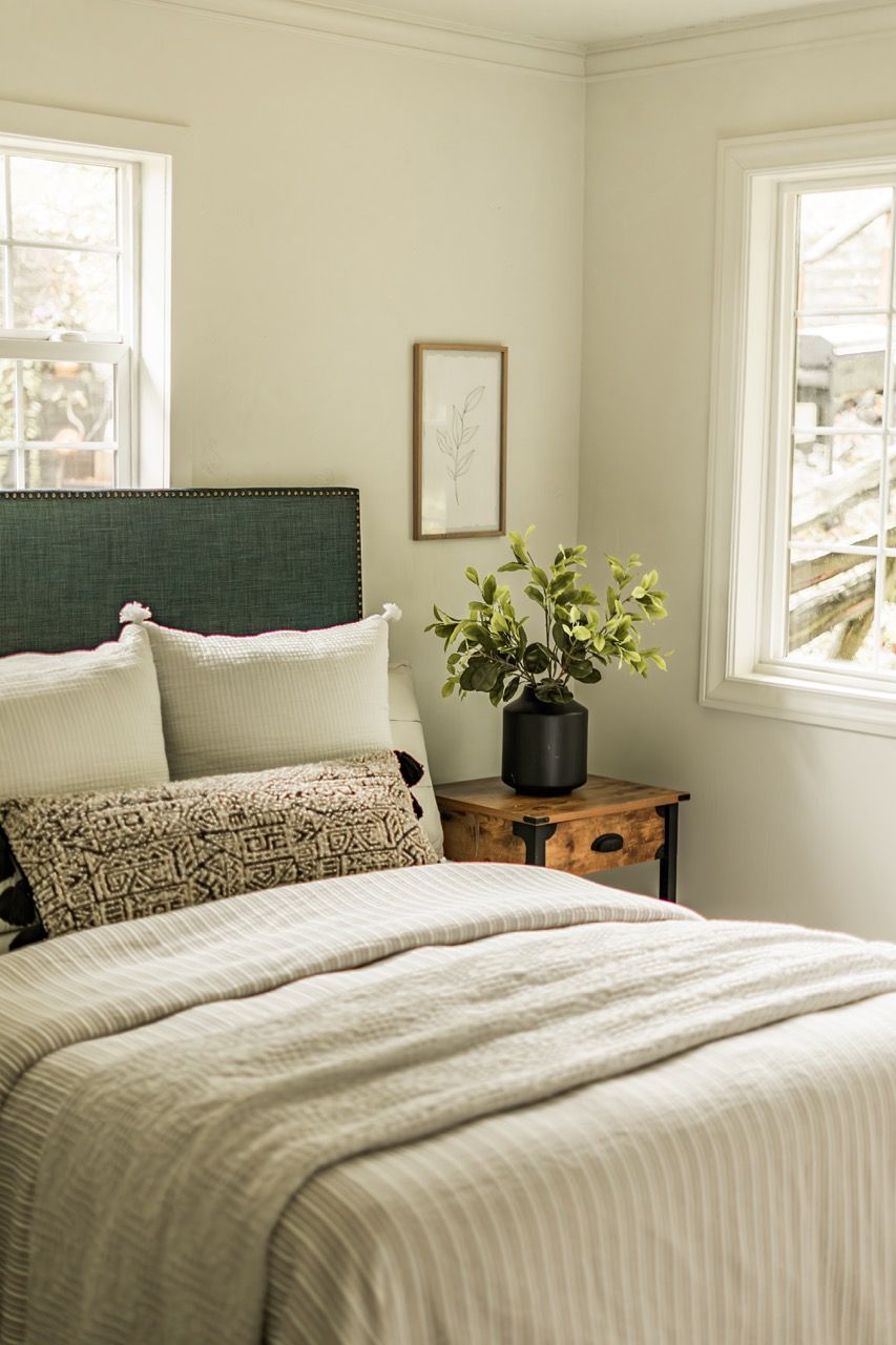 A bedroom with a bed , nightstand , and window.