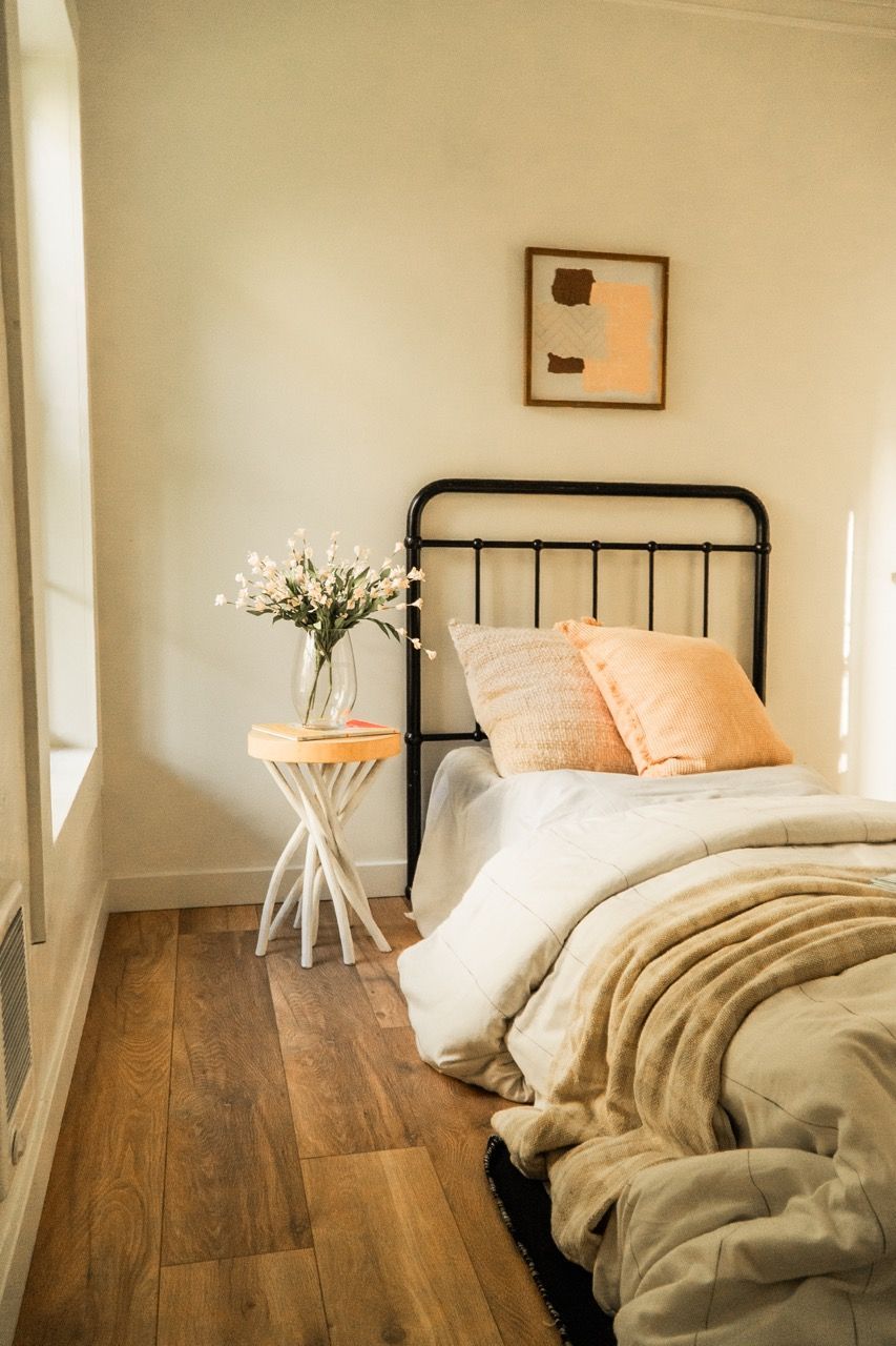 A bedroom with a bed , nightstand , and window.