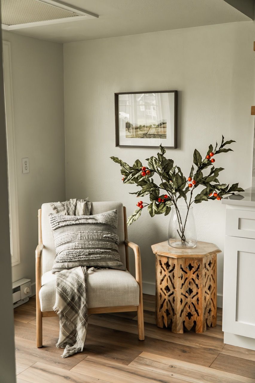 There is a chair and a table in the corner of the room.