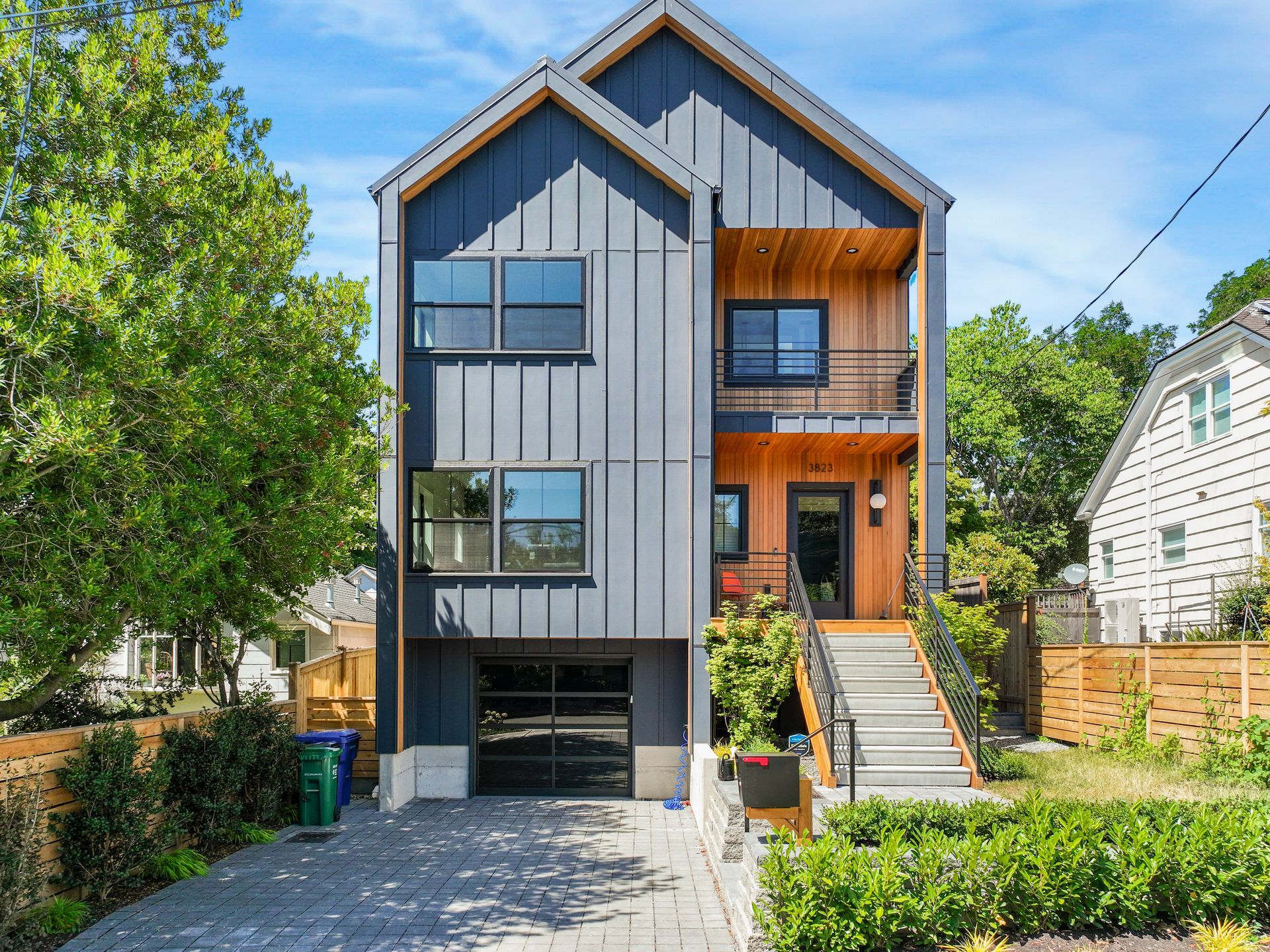 A modern house with a garage and stairs is for sale.